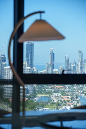 Une vue sur les gratte-ciel modernes d’une ville, un plan d’eau et une perspective à travers une fenêtre avec une lampe.