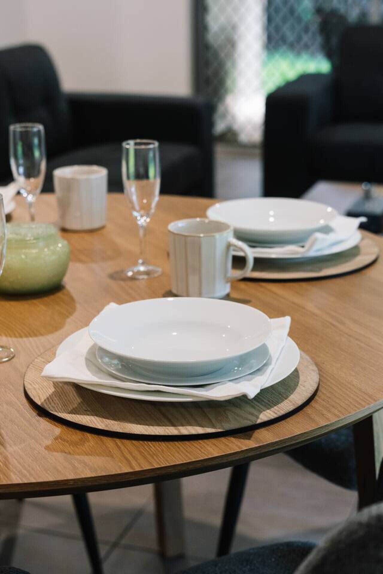 A dining table set with plates, a mug, and a glass.