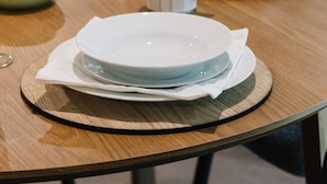 Una mesa puesta con platos, una taza y un vaso.