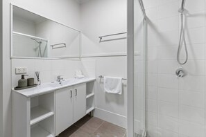 A modern bathroom with a shower, a sink, a mirror, and a towel rack. - Comfort Nest|2BR Quiet Comfort Retreat for Relax (Mount Warren Park)