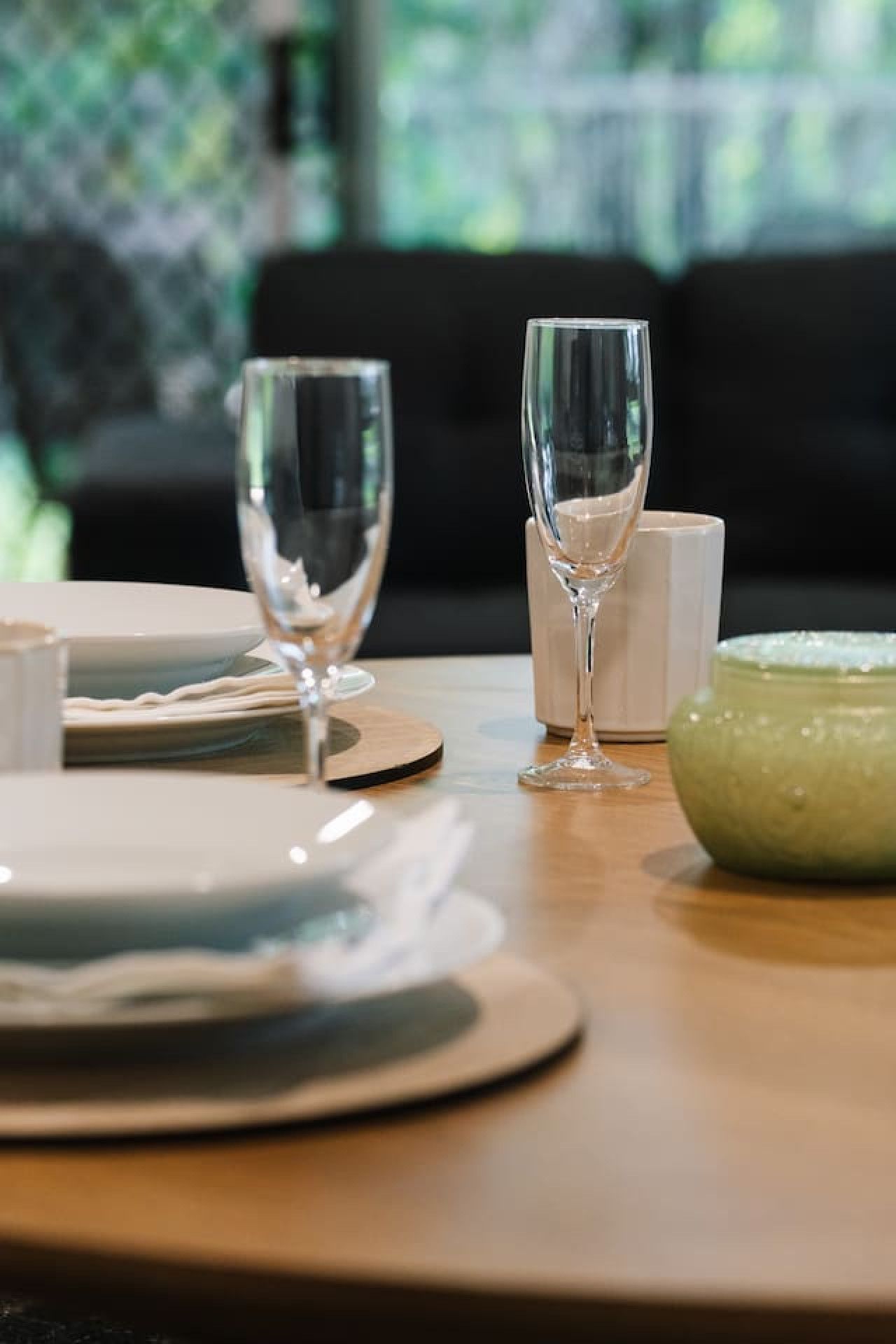 Une table à manger avec des assiettes, des verres et un saladier.