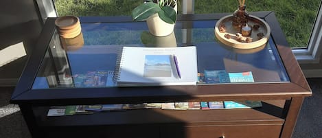 A glass-top desk with a notebook, a pen, and a small potted plant.
