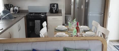 A modern kitchen with white cabinets, a black stove, and a refrigerator.