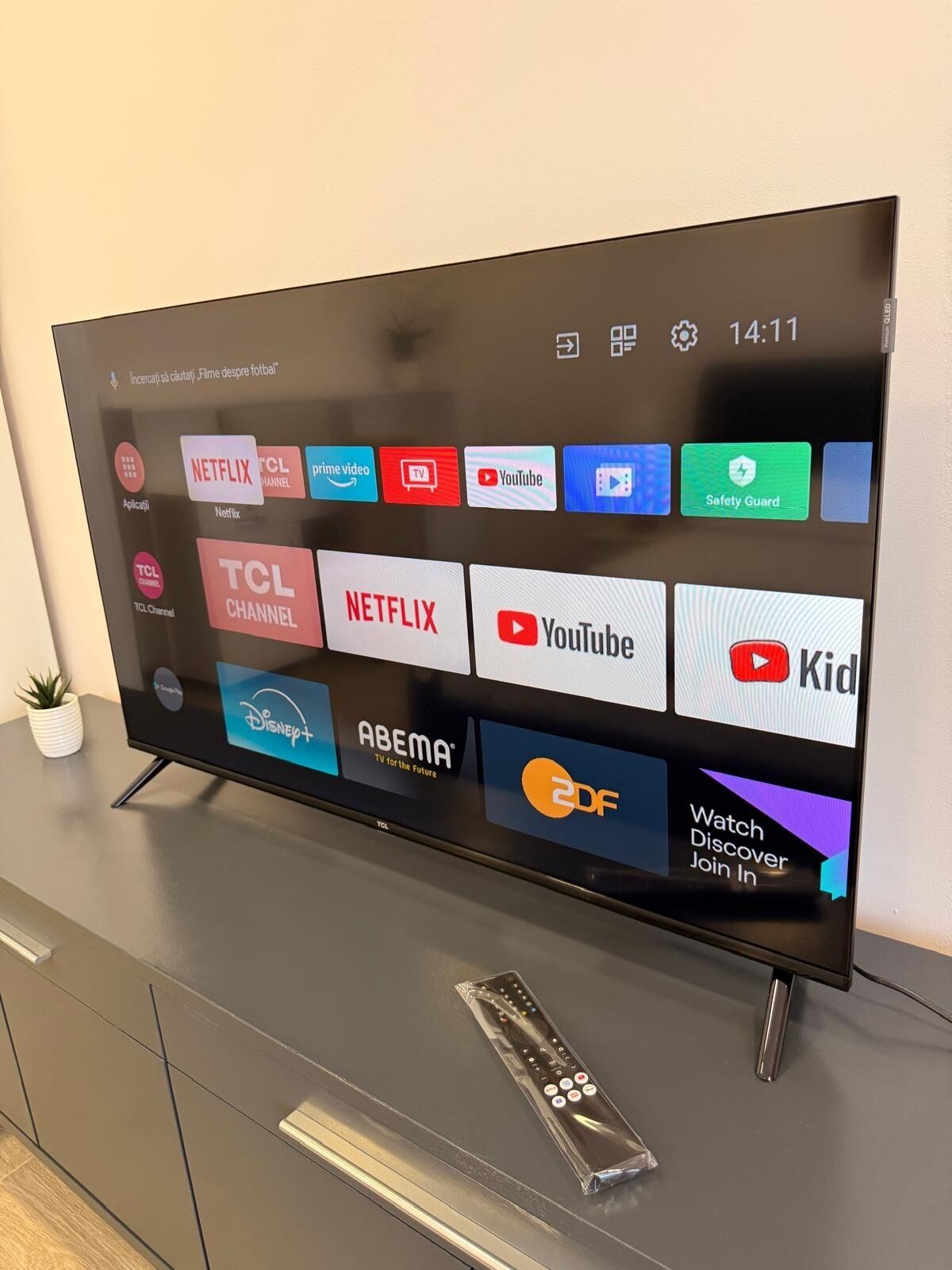 A flat-screen TV on a cabinet with a remote control.