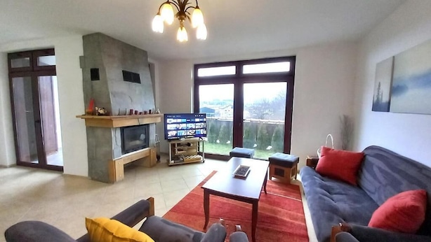 Ein Wohnzimmer mit Kamin, einer Couch, einem Couchtisch und einem Fernseher.