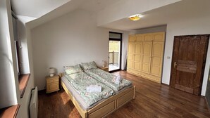 Ein Schlafzimmer mit einem hölzernen Bett, einem Nachttisch, einem Kleiderschrank und einer Tür.
