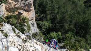 A mountainous landscape with a village below, rocky cliffs, and a person rappelling down a cliff. - Guest Room “La Grande Calade” with Mountain View, Terrace and Wi-Fi (Garde-Colombe)