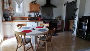 A kitchen with a dining table, chairs, a stove, and a refrigerator. - Guest Room “La Grande Calade” with Mountain View, Terrace and Wi-Fi (Garde-Colombe)