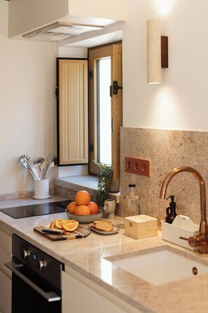 A kitchen with a sink, countertop, and cabinets. - Graça Gate | Mouraria Duplex (Lisbon)