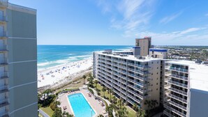 A high-rise hotel with a pool, beach view, and multiple balconies. - Tradewinds #1108 - Beachfront 1BR + Bunks, Gulf View, Indoor/Outdoor Pool (Orange Beach)
