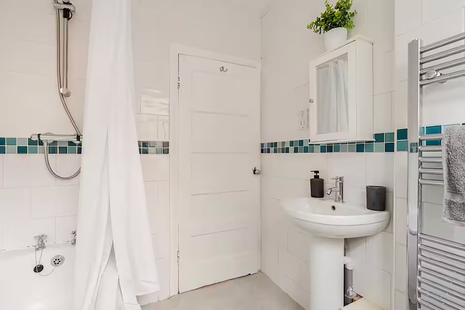 Ein Badezimmer mit Dusche, Waschbecken, Spiegel und Handtuchhalter.