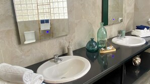 A bathroom with two sinks, a mirror, and a towel rack.