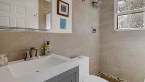 Un bany amb banyera, vàter i plat de dutxa.