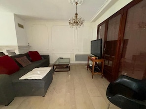 A living room with a sofa, a coffee table, a TV, and a cabinet. - Spacious House for 6-8 Guests | 2 Bathrooms | Easy Access to Paris (Noisy-le-Sec)