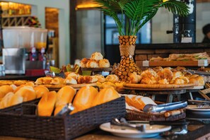 A buffet with various baked goods and a decorative plant in a vase. - Sitio Castelinho Hotel Fazenda (Cesário Lange)