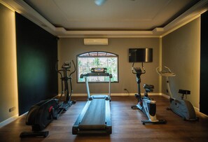 Ett hemmagym med löpband, crosstrainer, motionscykel och roddmaskin.