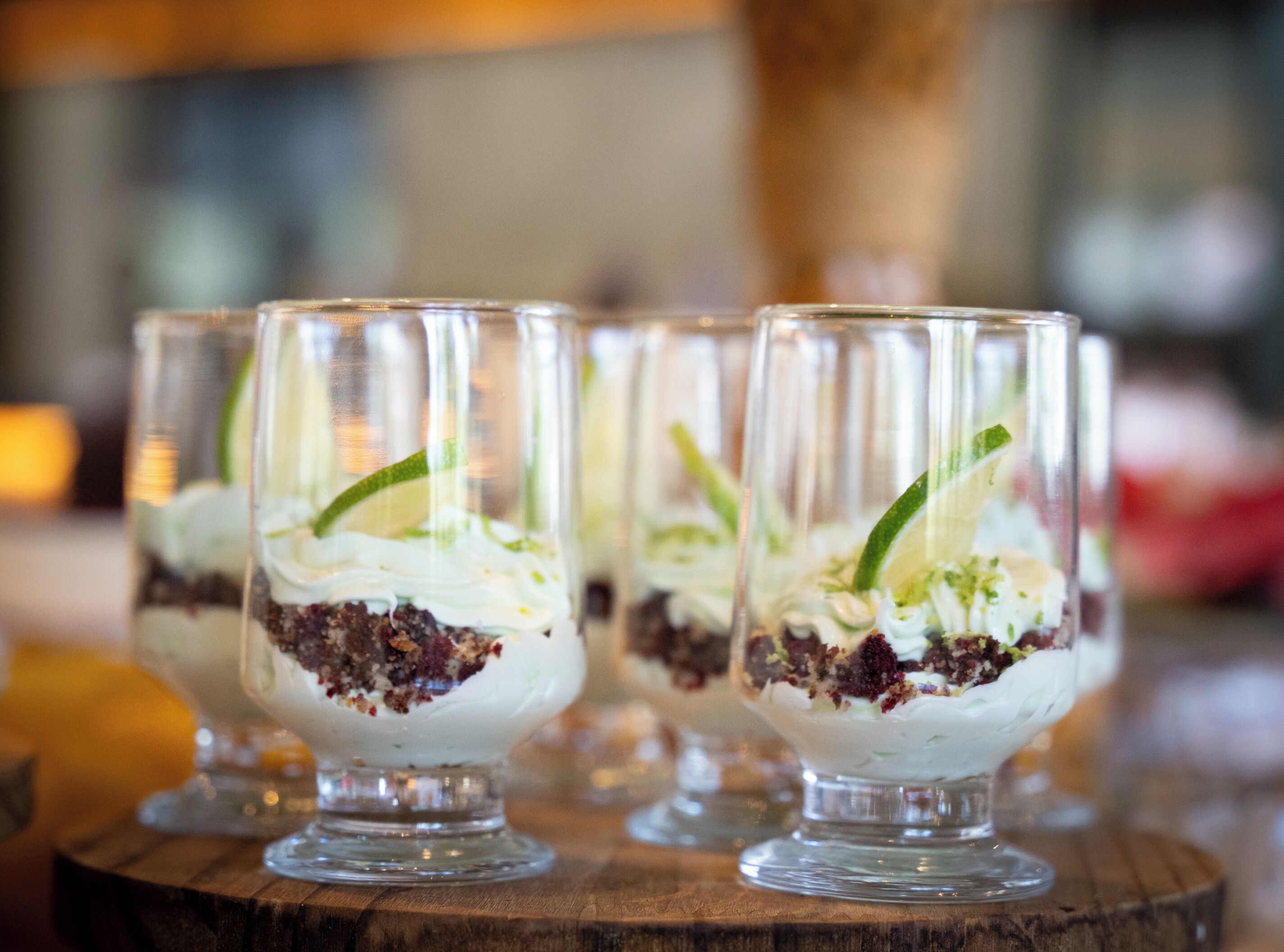 Cuatro vasos de postre sobre una superficie de madera.