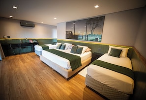 Ett hotellrum med två sängar, ett skrivbord och ett stort fönster med utsikt.
