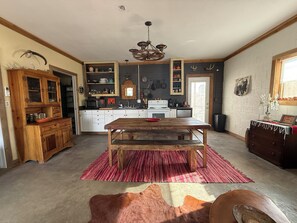 A kitchen with a wooden table, red rug, and a cowhide rug.