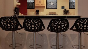 A kitchen with a ceiling fan, recessed lighting, and a window with a diamond-patterned blind.