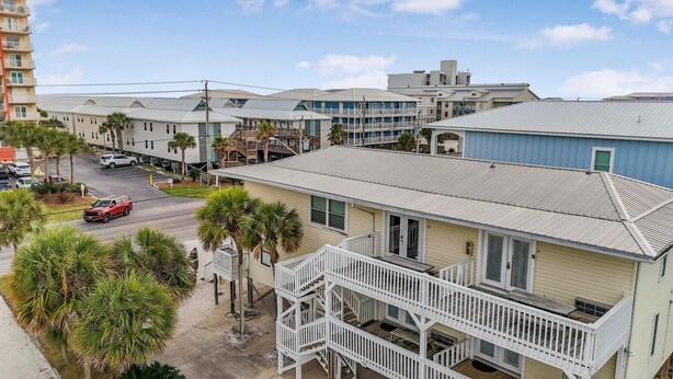 A coastal hotel with multiple stories, balconies, and a parking area. - Moonraker 15 (Gulf Shores)