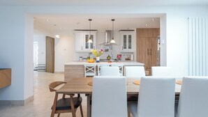 A modern kitchen with white cabinets, a central island, and pendant lighting. - Luxurious 3BDR 3BATH Hounslow by the Airport (Greater London)