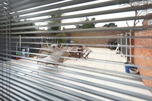 A patio area with a table and chairs, a brick wall, and a fence. - Luxurious 3BDR 3BATH Hounslow by the Airport (Greater London)
