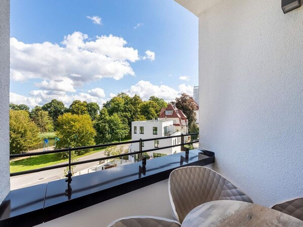 A balcony with a view of a residential area, a railing, and a chair. - 4 Star Holiday Home in Travemunde (Lübeck)