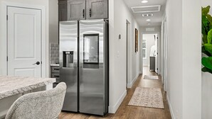 Une cuisine moderne équipée d’un réfrigérateur à deux portes, d’un plan de travail et d’une chaise.
