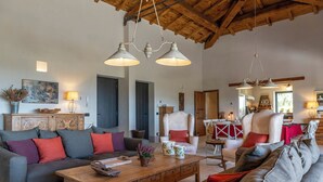 A living room with a wooden ceiling, a sofa set, a coffee table, and hanging pendant lights. - I Tramonti 10+2, Emma Villas (Montegabbione)