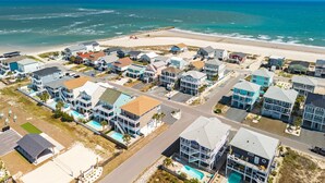 Una zona residenziale costiera con case, una spiaggia e cielo sereno.