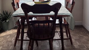 Comedor con una mesa, sillas, vista al agua y una lámpara en el techo.
