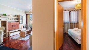 Ein Hotelzimmer mit Bett, Schreibtisch, Fernseher und einem Balkon mit Blick.