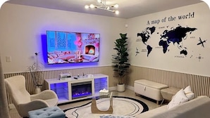 A living room with a television, a world map, and a fireplace. - 3bedroom-Free Parking LakeView-Sunset-Balcony-Central - 24hr Security Patrol (Homestead)