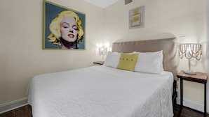 A hotel room with a large bed, a ceiling fan, a painting on the wall, and a bedside table with a lamp. - Private Room Near Wynwood Free Parking (Miami)