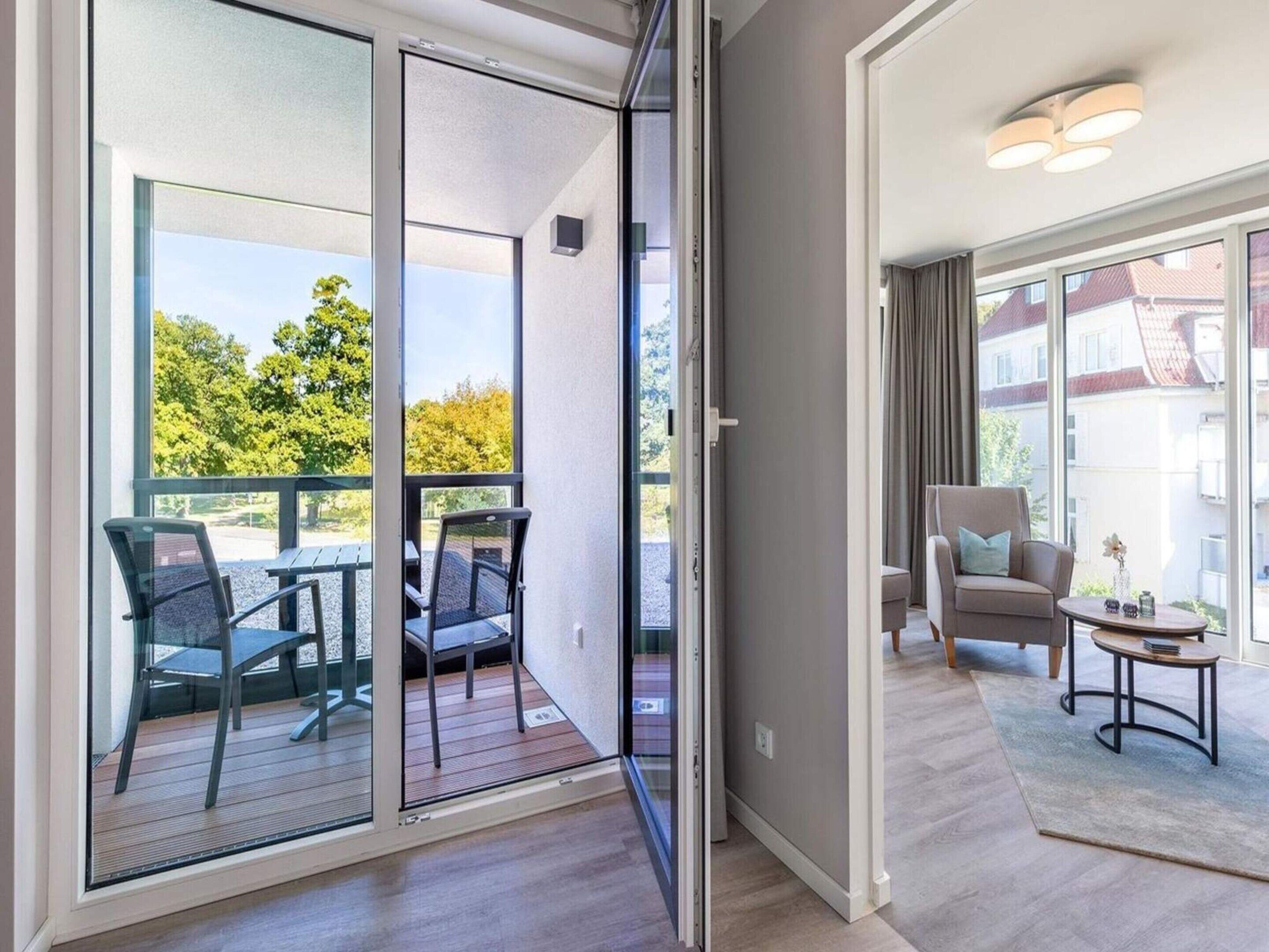 A modern apartment with a balcony, a sofa, and a small table.
