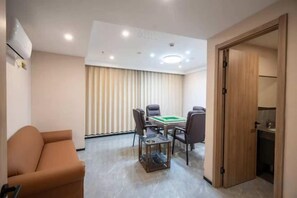 Une pièce comprenant une table de billard, un canapé et une porte donnant sur une salle de bain.