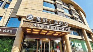 A hotel entrance with a sign indicating 'HUA SHU YI HOTEL' and a revolving door. - Wuzhou Hotel (Pinghu)