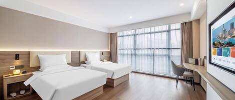 A modern hotel room with two beds, a desk, and a large window.