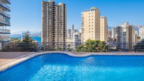 Piscina com paisagem urbana ao fundo.