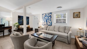A living room with a sofa, armchairs, a coffee table, and artwork on the walls. - Artsy Room with Free Parking (Miami)