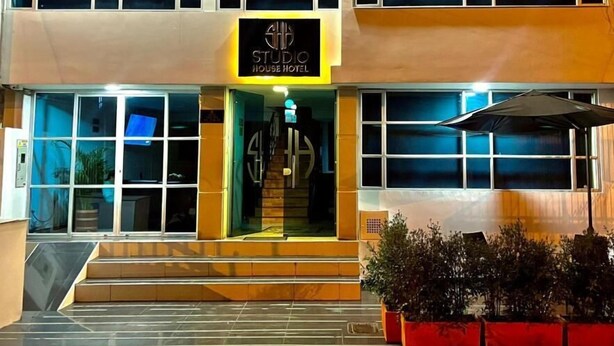 A two-story building with a sign reading 'STUDIO HOUSE HOTEL' at the entrance. - Studio House Hotel (Bogotá)