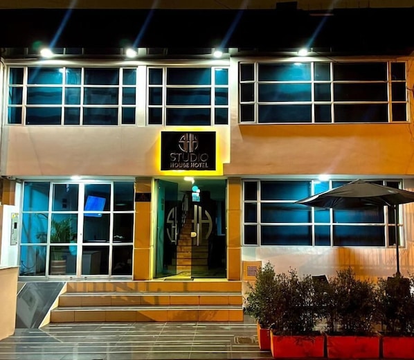 A two-story building with a sign reading 'STUDIO HOUSE HOTEL' at the entrance. - Studio House Hotel (Bogotá)