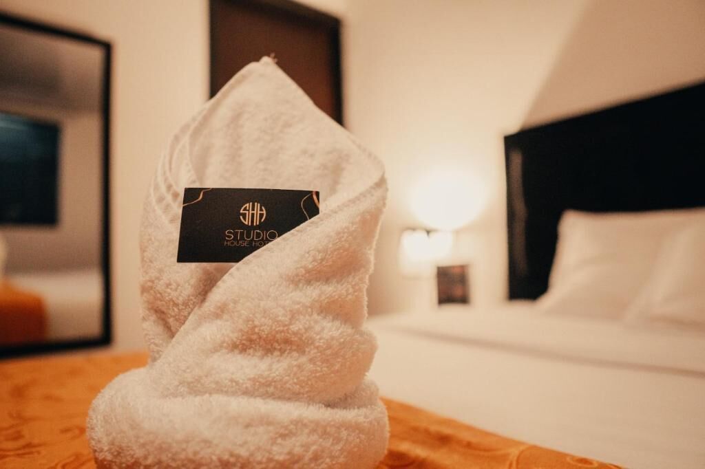 A neatly folded towel with a label on a wooden surface in a hotel room.