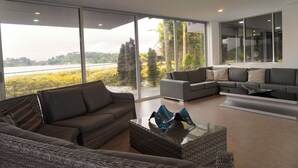 Ein modernes Wohnzimmer mit großem Fenster, einem Sofa, einem Couchtisch und einer Eckcouch.