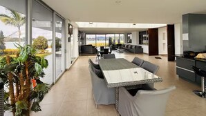 Ein modernes Interieur mit Essbereich, Küche und großen Schiebeglastüren mit Blick.