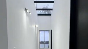 Ein moderner Flur mit Oberlicht, großem Fenster und Blick ins Freie.