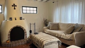 Ein gemütliches Wohnzimmer mit Kamin, einer Couch und einem Couchtisch.