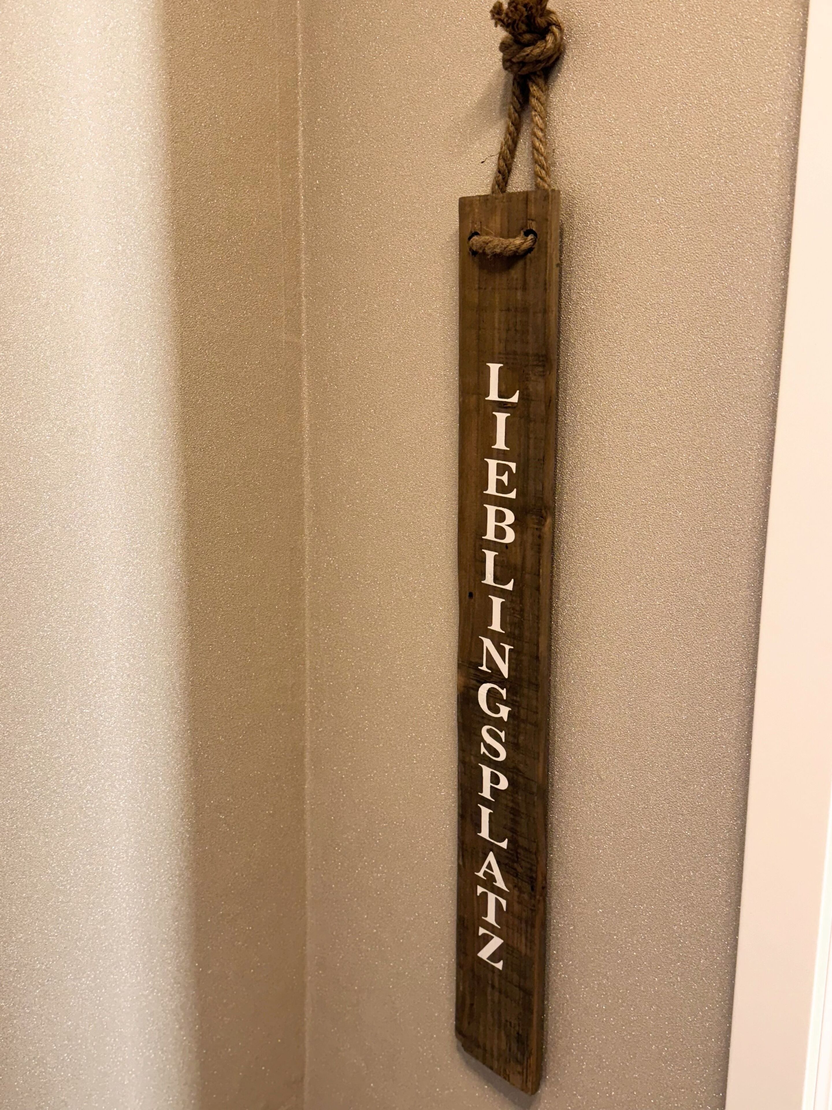 Une enseigne en bois portant l’inscription « LIEBLINGSPATZ » est accrochée à un mur.