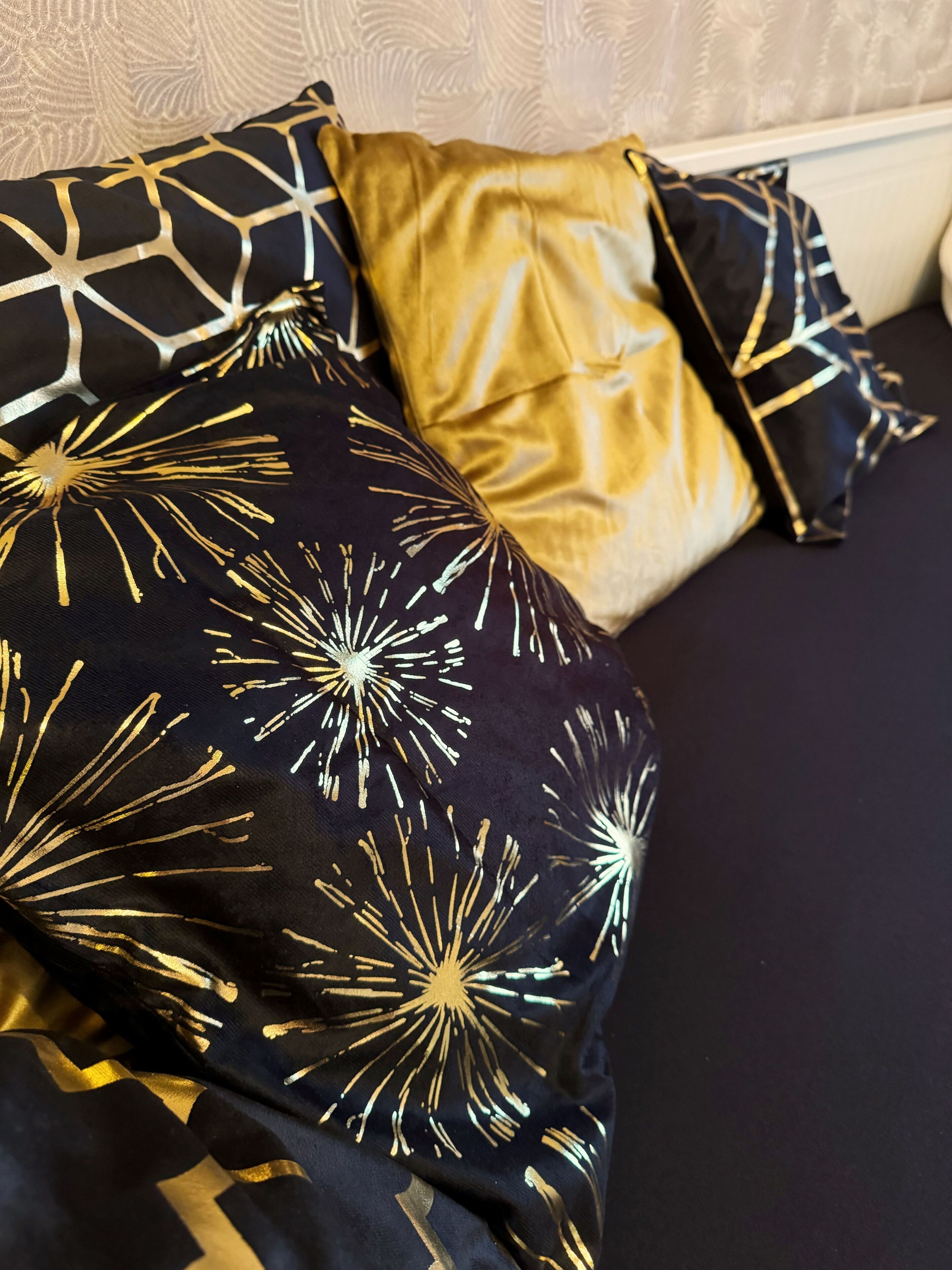 Una cama con ropa de cama y almohadas estampadas.